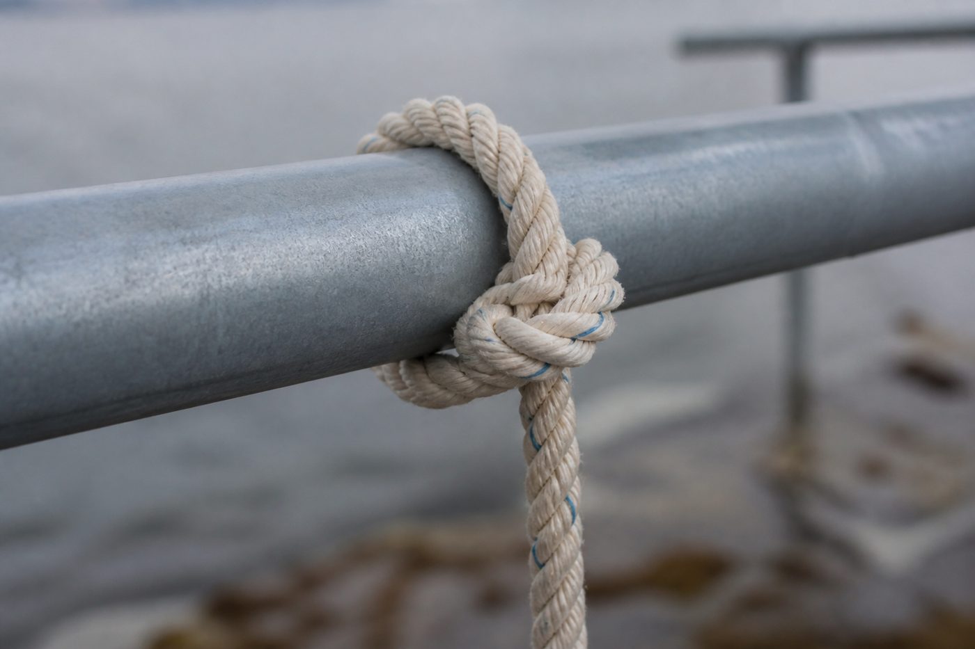 A length of rope tied with a hitch around a metal rail
